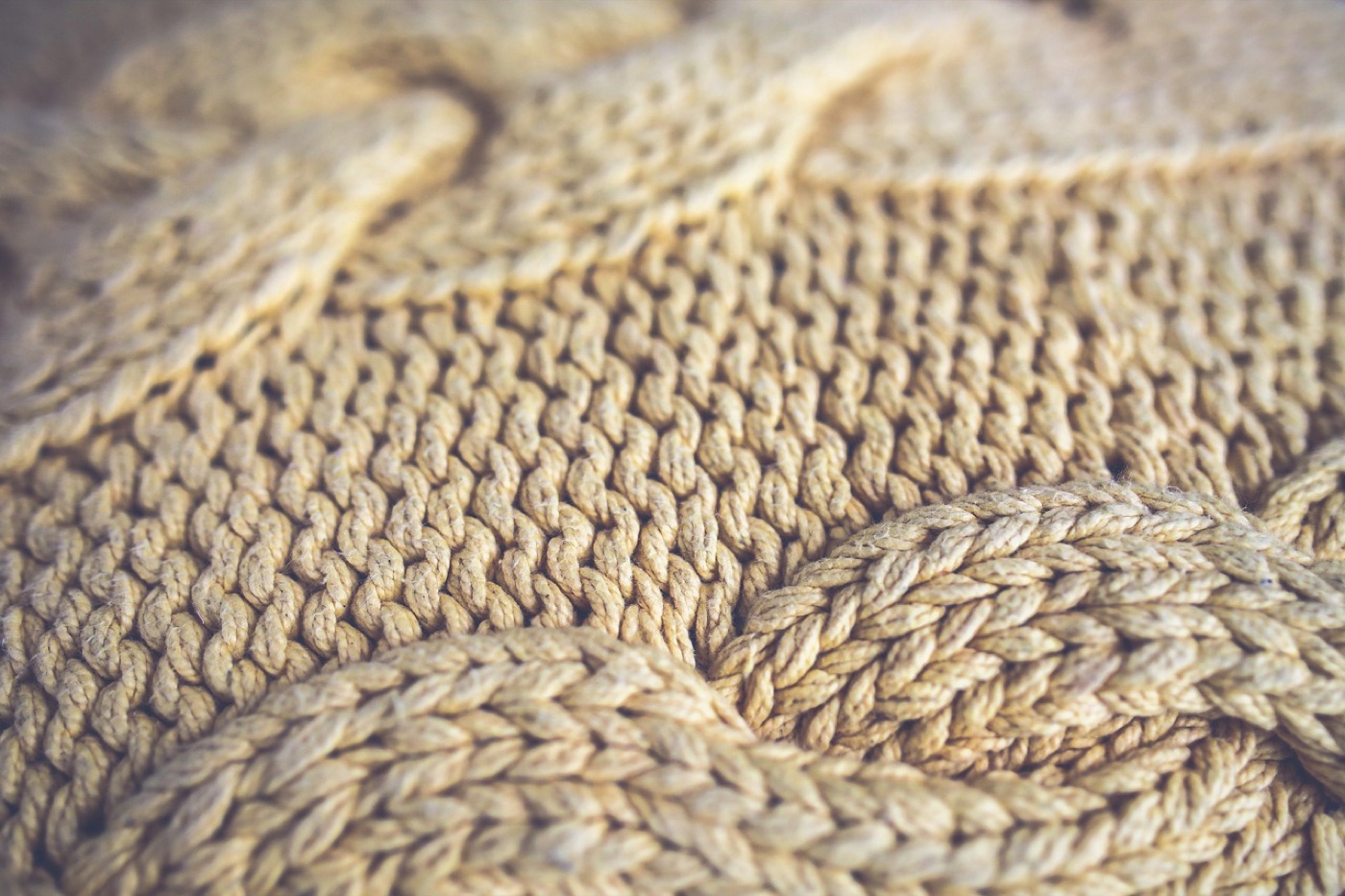 A knitted wool throw seen close up, the stitch pattern and the fabric weight both legible.